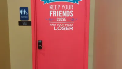a photo of a dominos pizza restroom door. A graphic on the door reads "Keep your friends close and your pizza closer", but someone has removed the letter C from the graphic, so the latter half of the phrase reads "Keep your pizza, loser"
